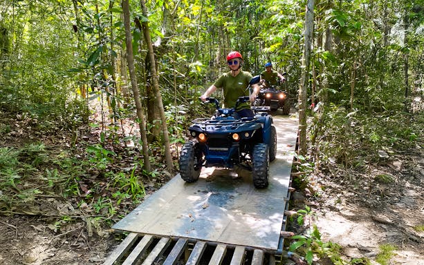 ATV riders navigating forest trail on Langkawi Sky ATV Ride, Mountain Manchinchang.