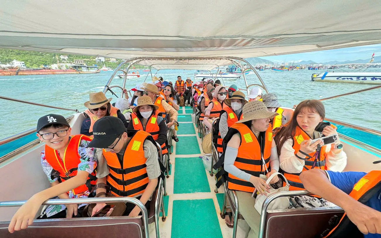 Tourists on a boat wearing life jackets during Nha Trang island-hopping adventure.