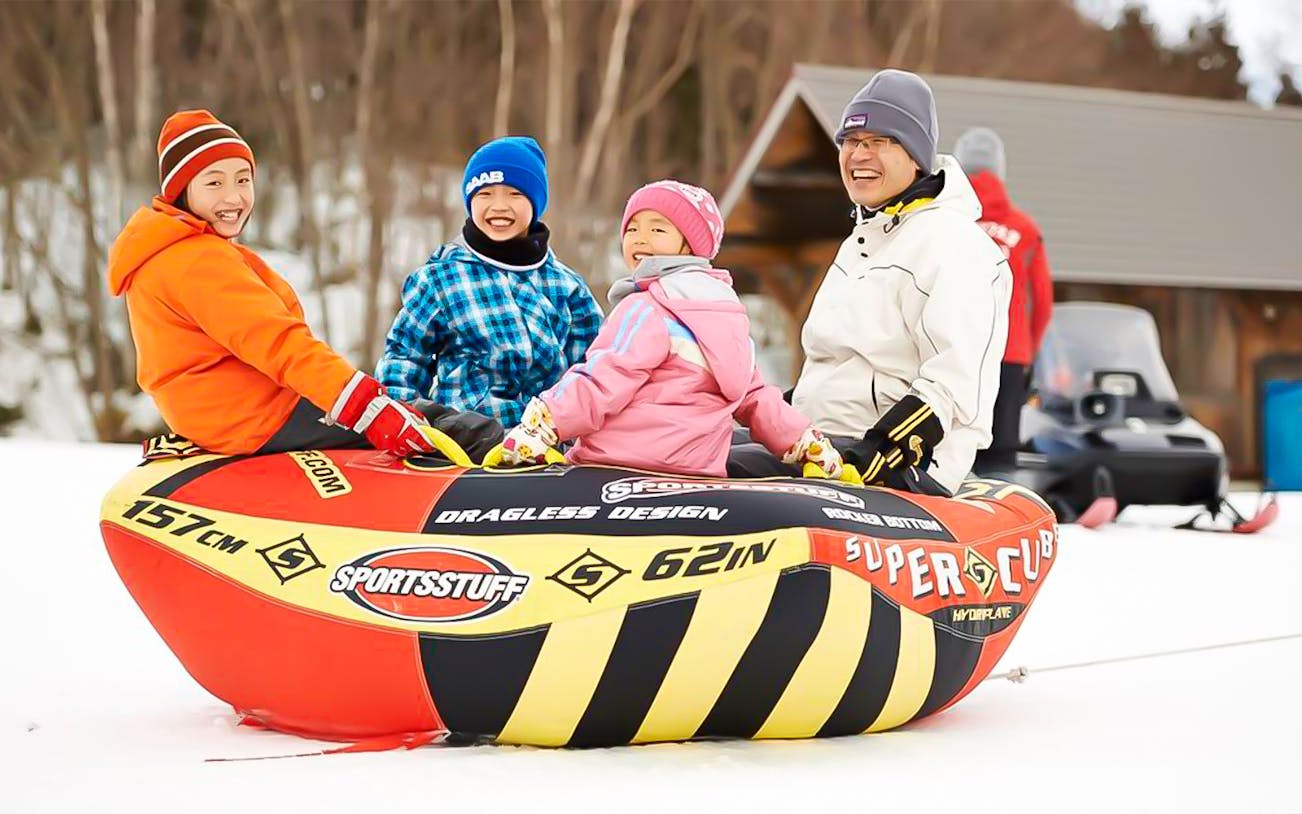 Group enjoying snow tubing at Greenpia Onuma Ski Resort.