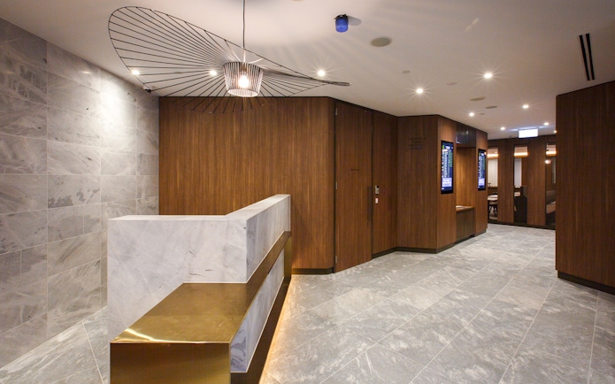 Plaza Premium Lounge entrance with marble counter and modern decor.
