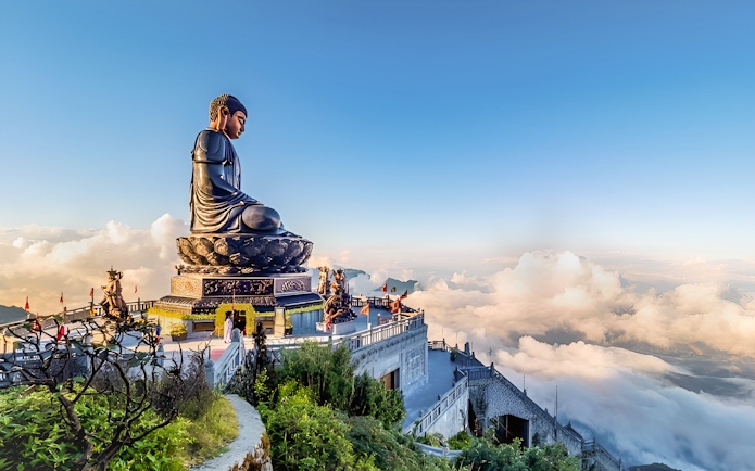 Buddha statue at Sun World Fansipan Legend, Vietnam, surrounded by clouds and mountain views.