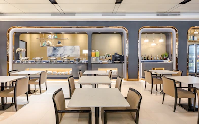 Dining area at Miracle Lounge, Bangkok Airport, featuring buffet and seating.