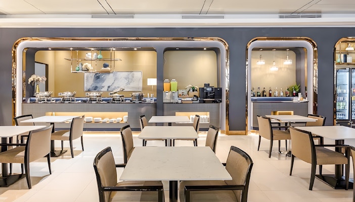 Dining area at Miracle Lounge, Bangkok Airport, featuring buffet and seating.