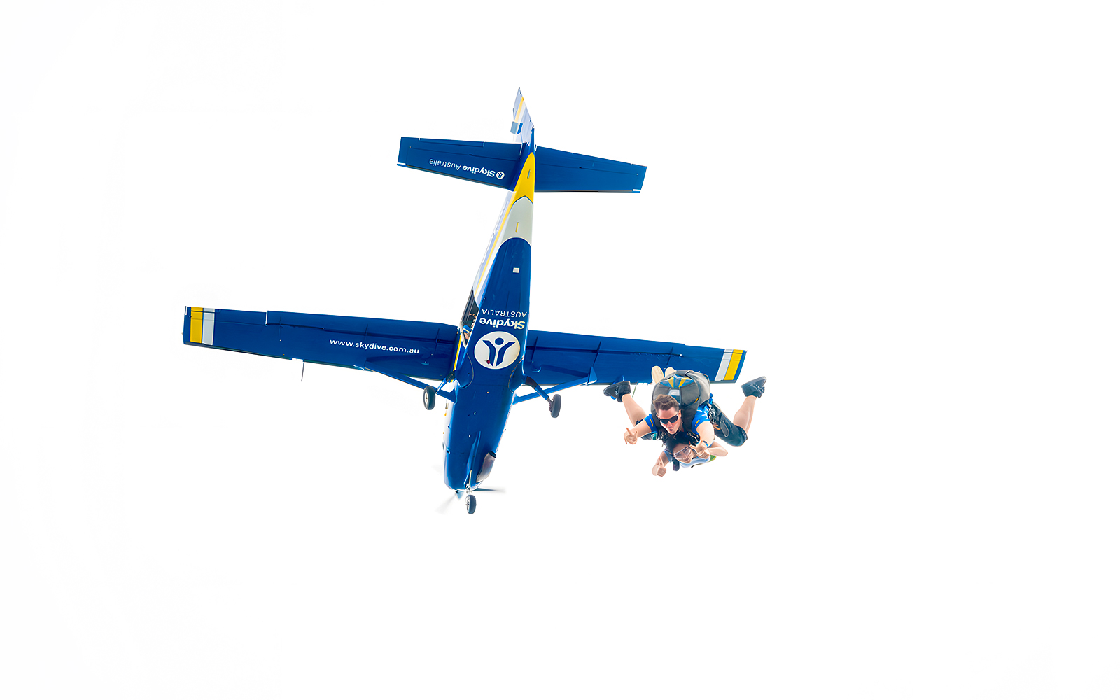 An instructor and a guest jumping off a plane to skydive