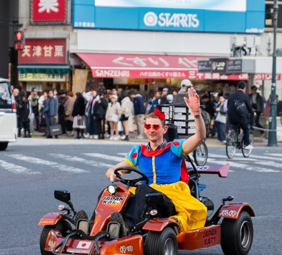 Tourists in costumes go-karting through Shibuya crossing in Tokyo.