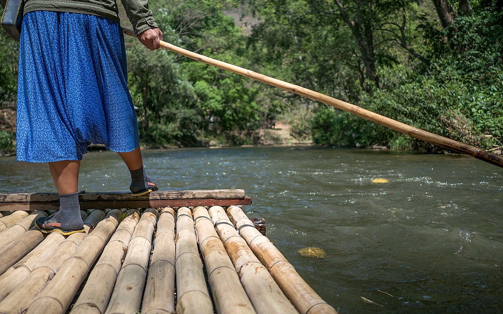 Wooden raft boat floating on the Li River with karst mountains in Guilin, China.