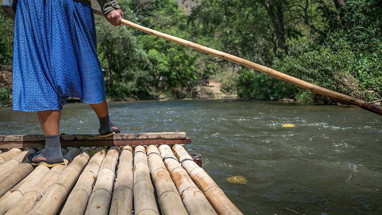 Wooden raft boat floating on the Li River with karst mountains in Guilin, China.
