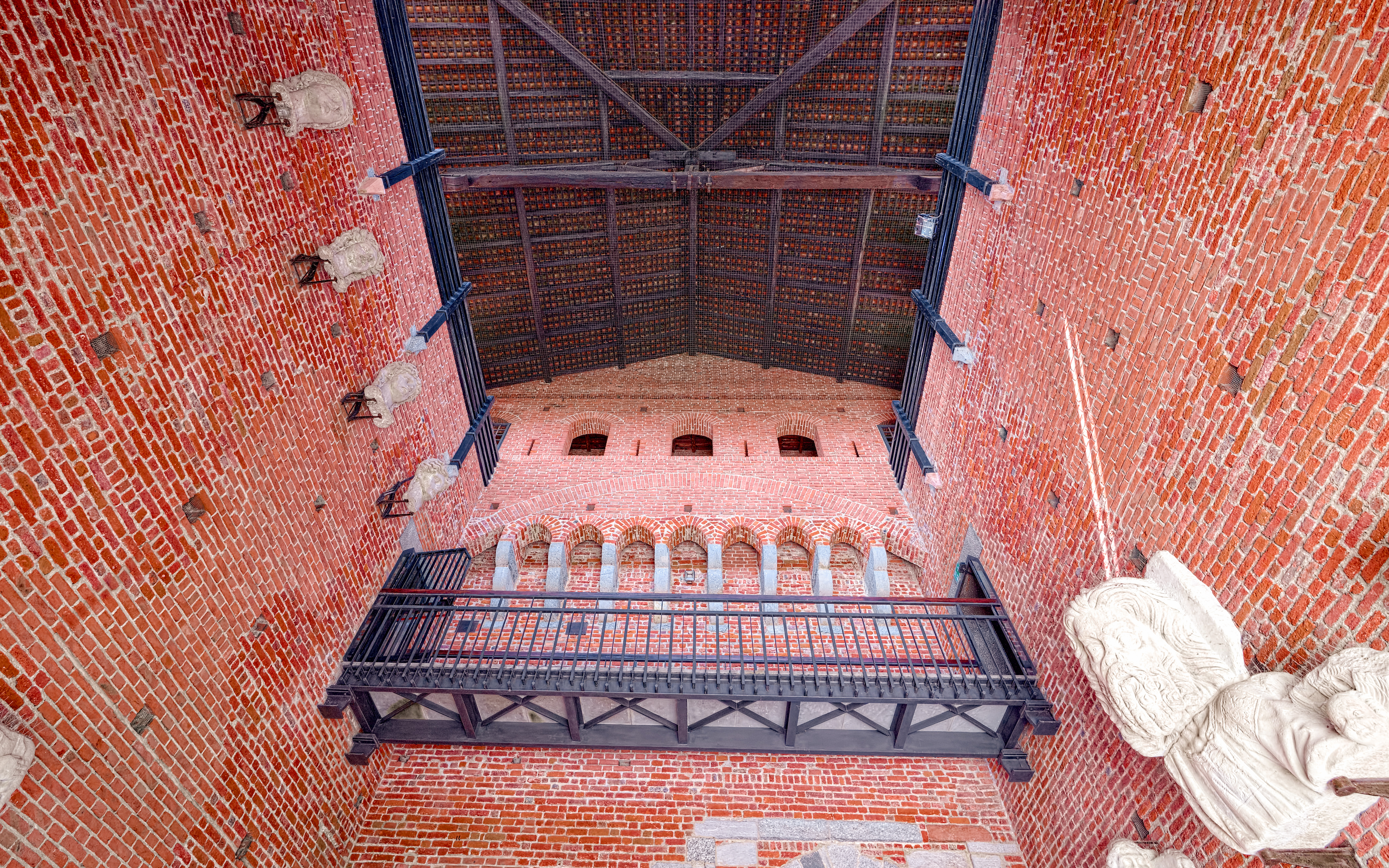 Interior brick wall and arches of Sforza Castle, Milan, with decorative stone elements.