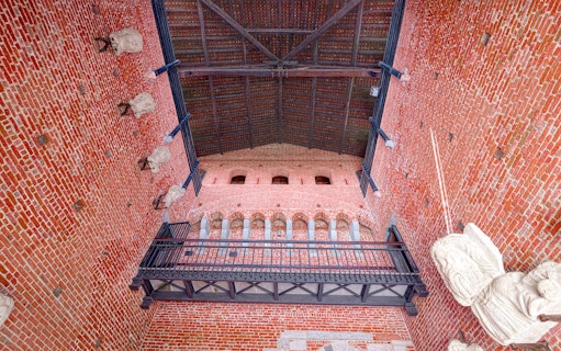 Interior brick wall and arches of Sforza Castle, Milan, with decorative stone elements.