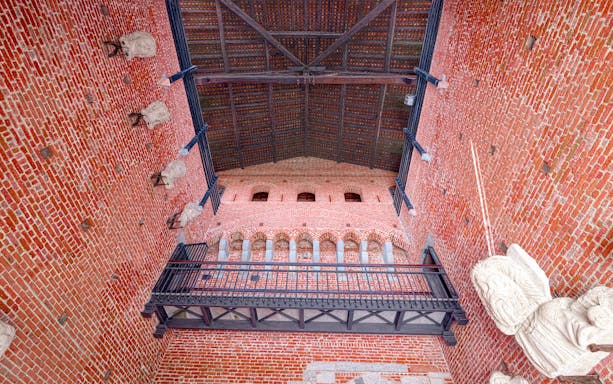 Interior brick wall and arches of Sforza Castle, Milan, with decorative stone elements.