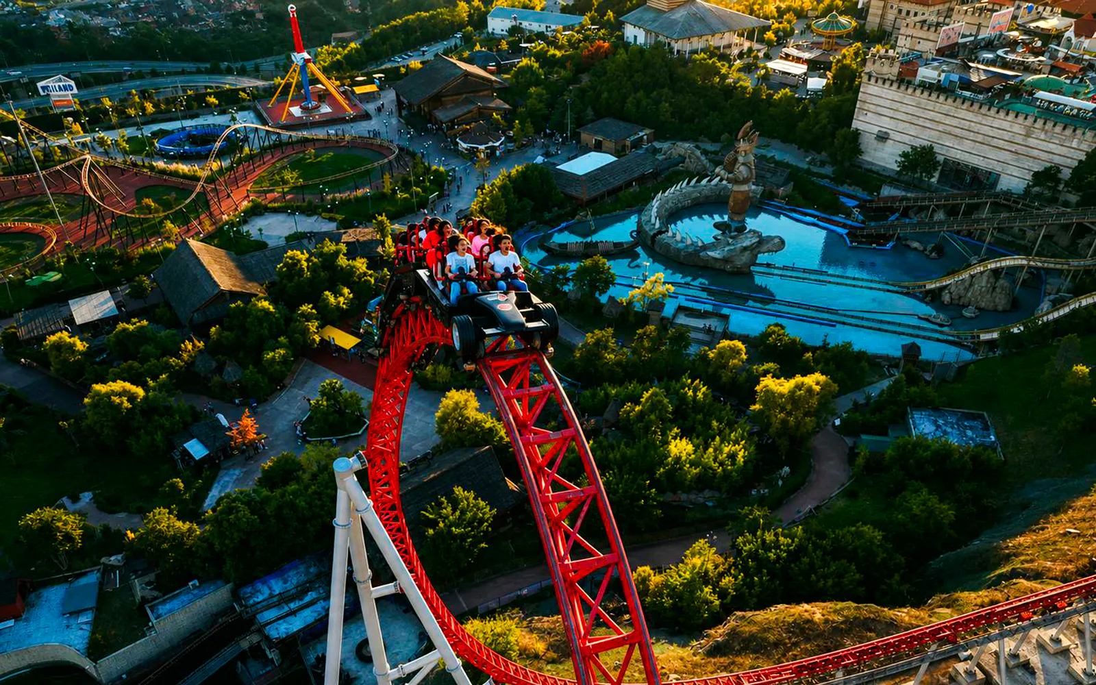 Guests riding a roller coaster at Vialand Theme Park, Istanbul, with park attractions visible.
