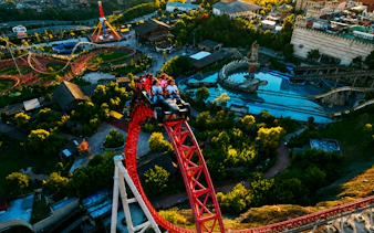 Guests riding a roller coaster at Vialand Theme Park, Istanbul, with park attractions visible.