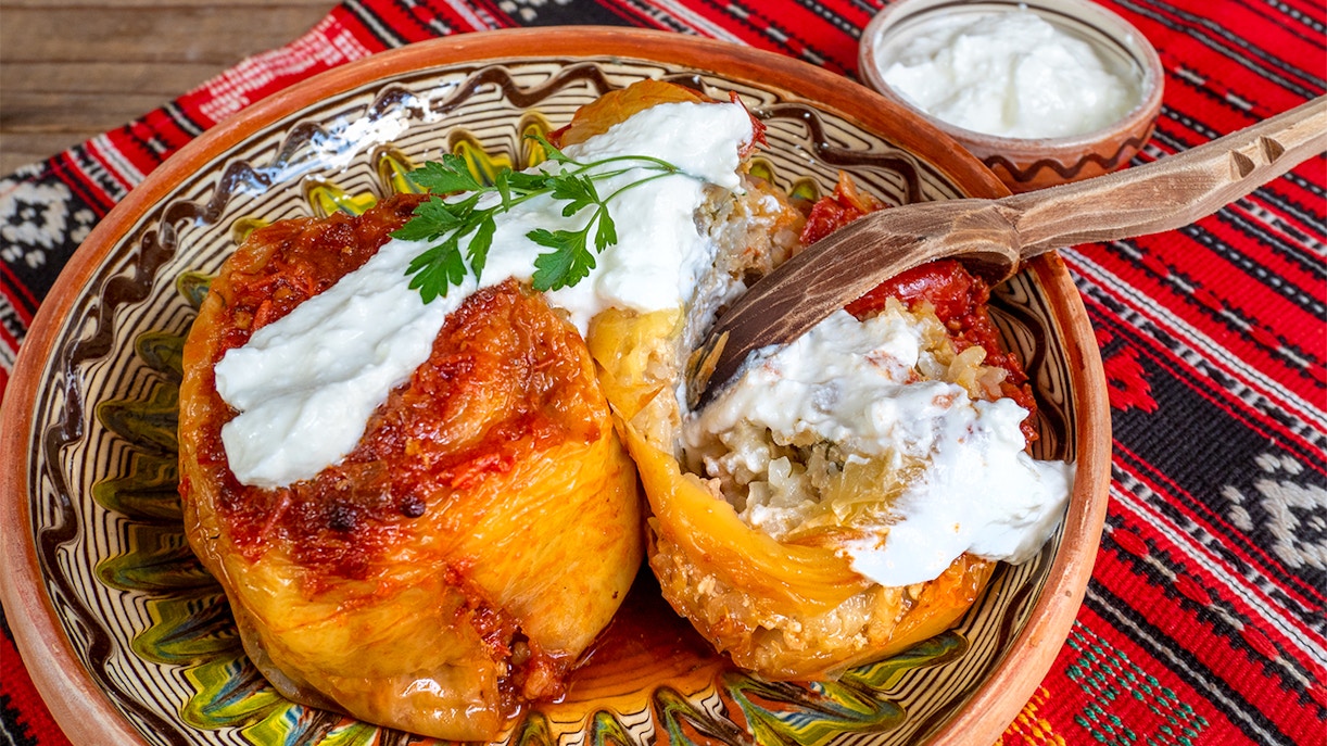 Bell peppers stuffed with minced meat, topped with sauce, Romanian cuisine.