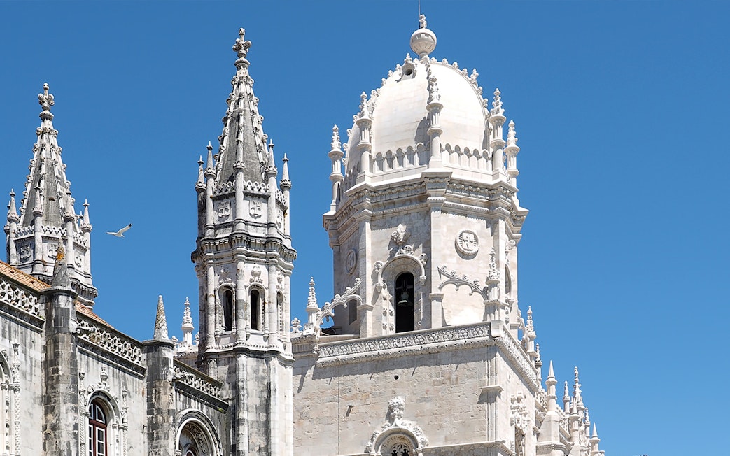 Jerónimos Monastery spires and dome against blue sky, Lisbon, Portugal.