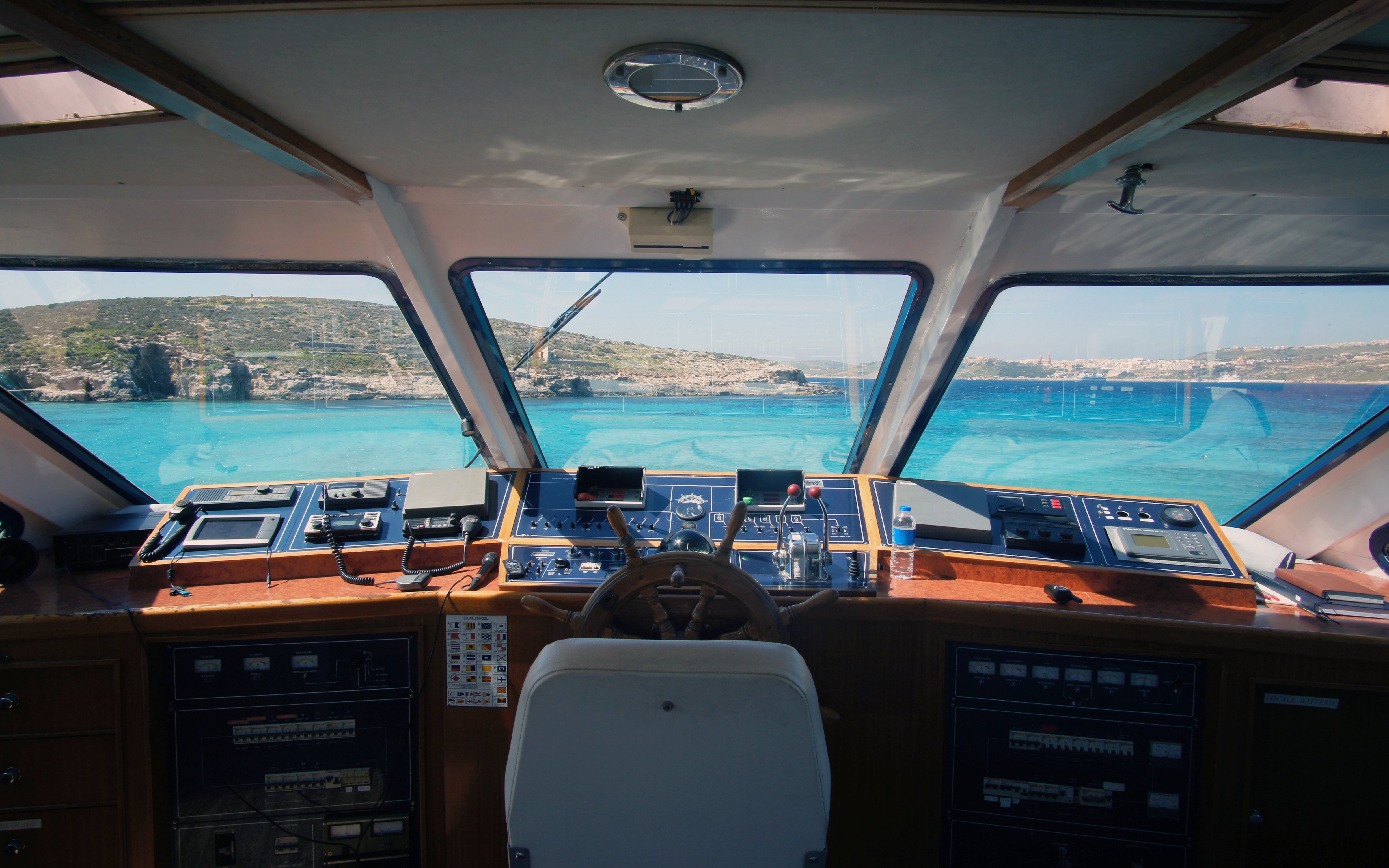 Cruise ship cockpit view of Gozo and Comino islands, Malta, with clear blue sea.