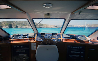 Cruise ship cockpit view of Gozo and Comino islands, Malta, with clear blue sea.