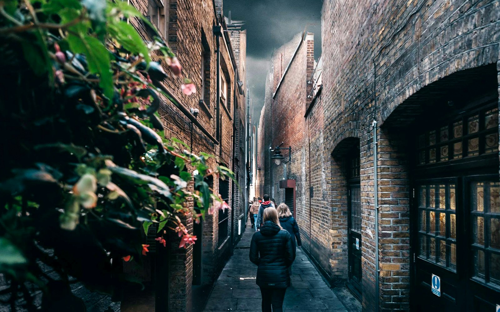 Walking tour group in narrow London alley, Harry Potter film location.