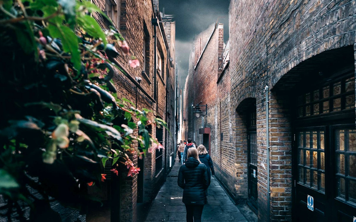 Walking tour group in narrow London alley, Harry Potter film location.