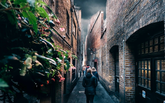 Walking tour group in narrow London alley, Harry Potter film location.