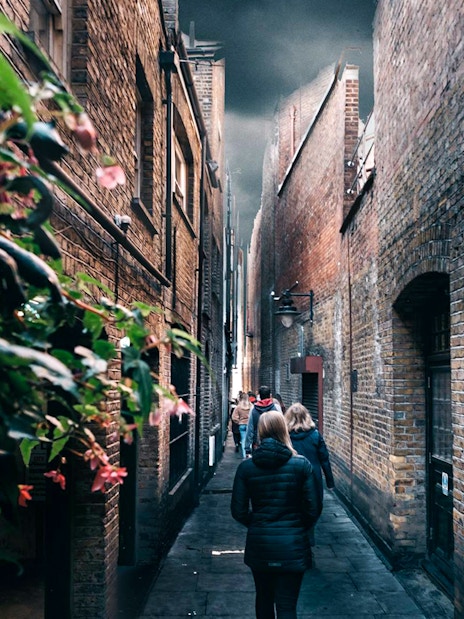 Walking tour group in narrow London alley, Harry Potter film location.