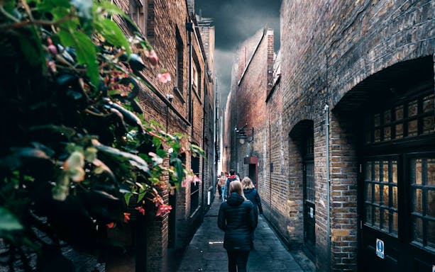 Walking tour group in narrow London alley, Harry Potter film location.