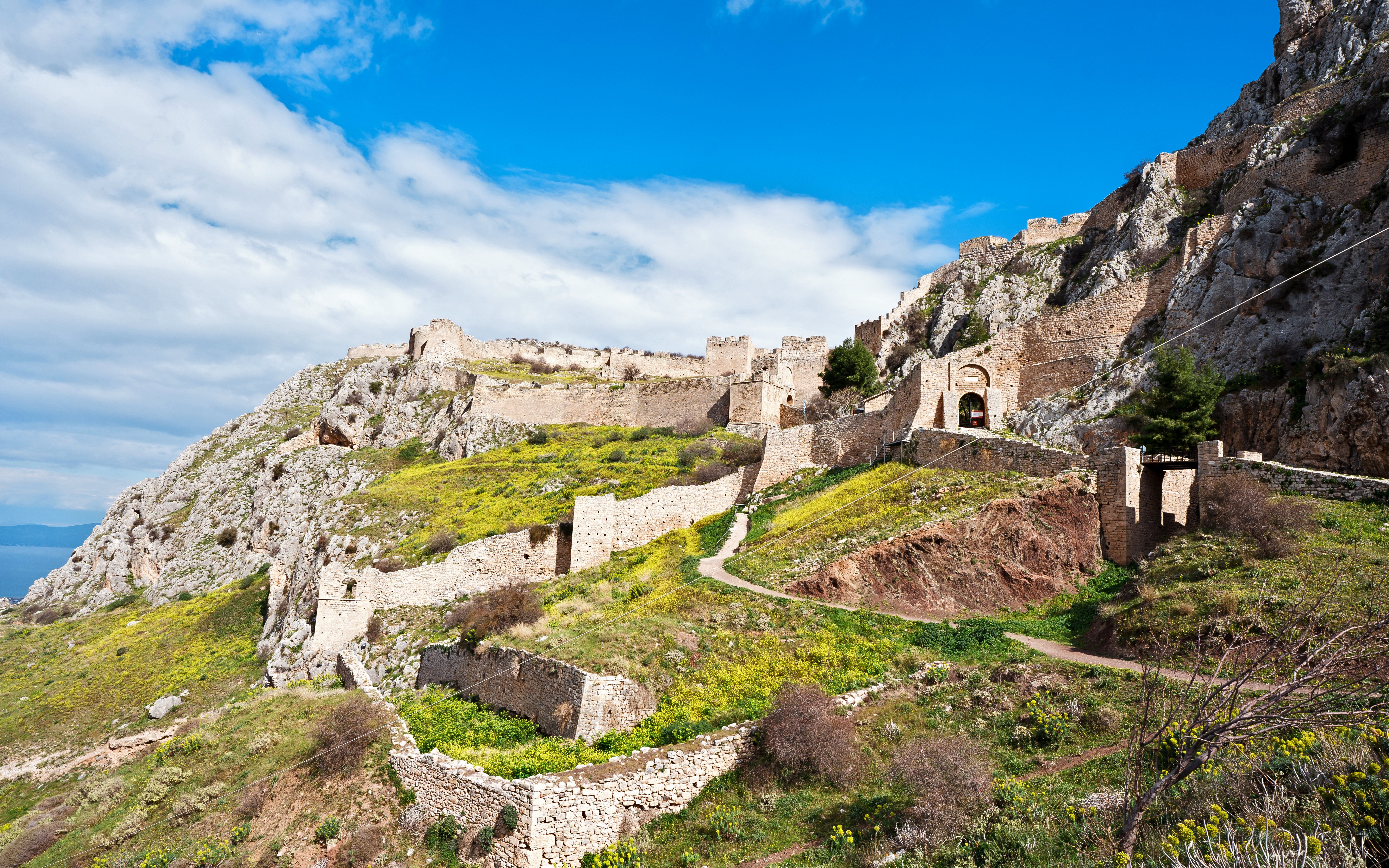 Acrocorinth Fortress on a hilltop with ancient stone walls and scenic landscape, Greece.