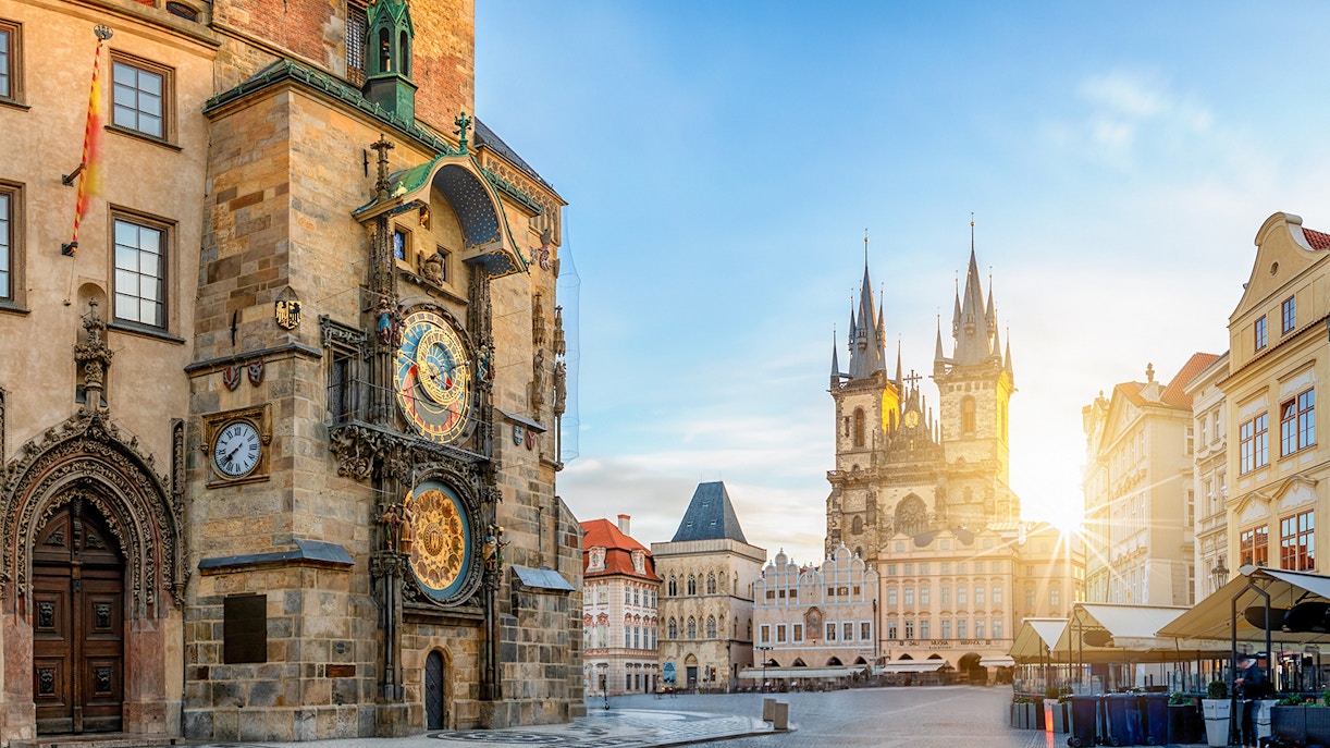 Prague Astronomical Tower in Old Town Square in early morning with sun peaking from behind