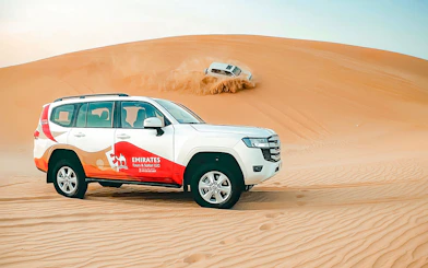SUVs driving on sand dunes during an overnight desert safari in Abu Dhabi.