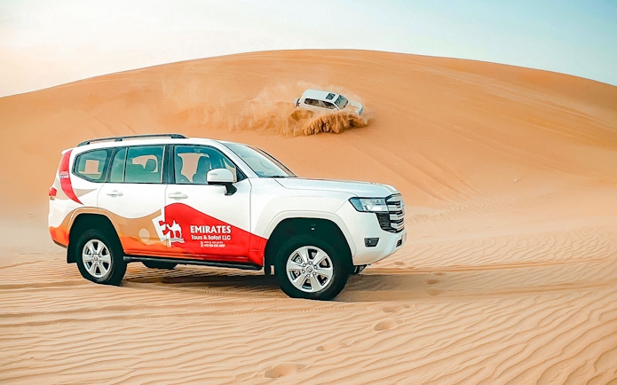 SUVs driving on sand dunes during an overnight desert safari in Abu Dhabi.
