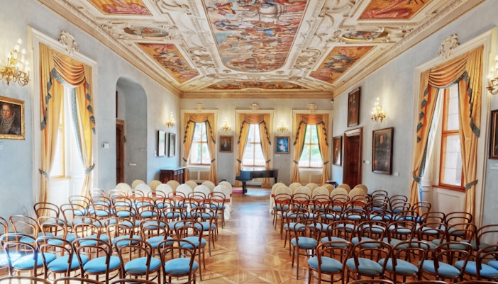 Lobkowicz Palace Museum interior with visitors using audio guides in Prague.