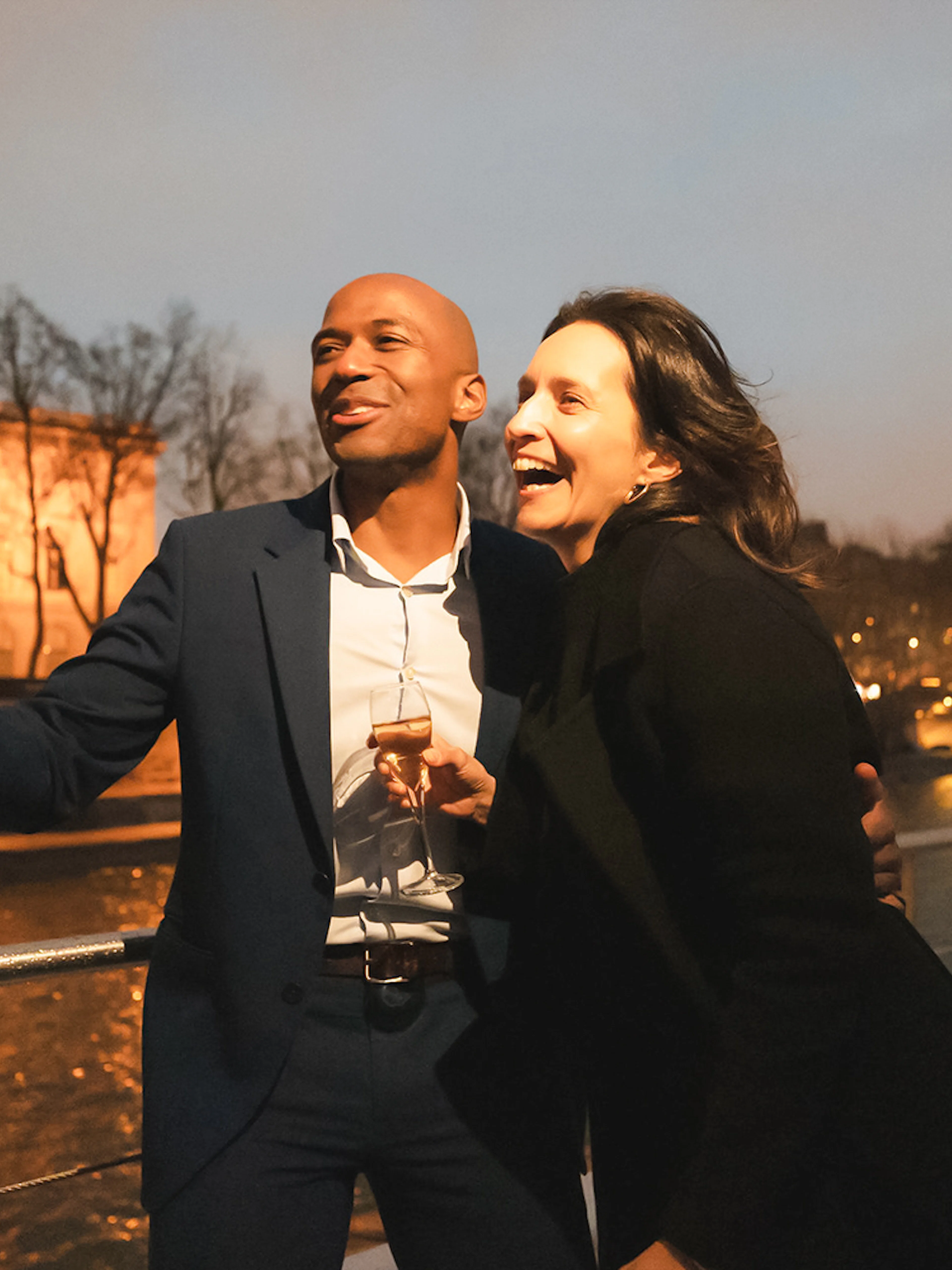 Couple enjoying a boat ride on Bateaux Mouches in Paris at night.