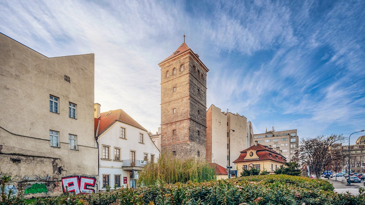 New Mill Water Tower in Prague surrounded by historic buildings and greenery.