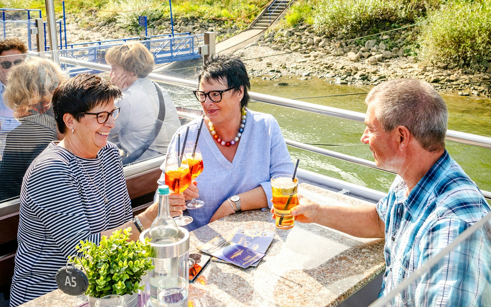 Koblenz sightseeing cruise with passengers enjoying drinks on the Rhine River.