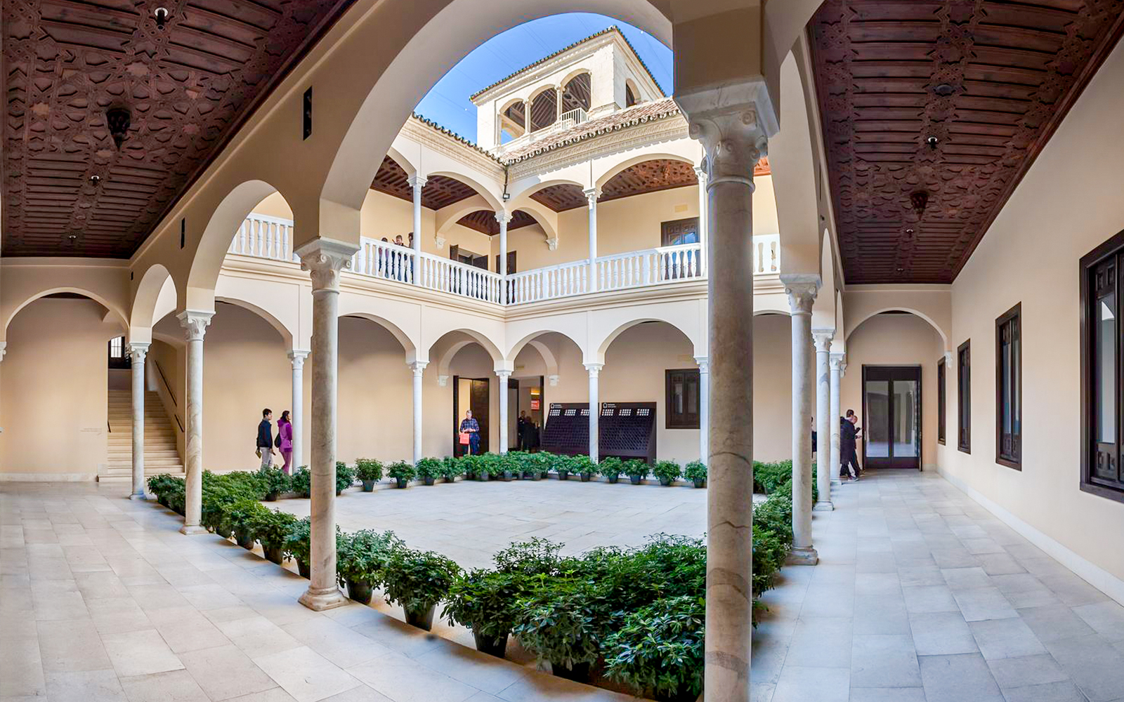 Courtyard of the Picasso Museum in Malaga with arches and potted plants.