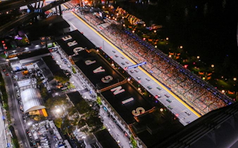 Aerial view of Formula 1 Singapore Grand Prix track with cars and audience.