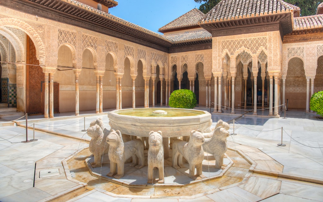 Courtyard of the Lions with ornate arches at Alhambra, Granada.