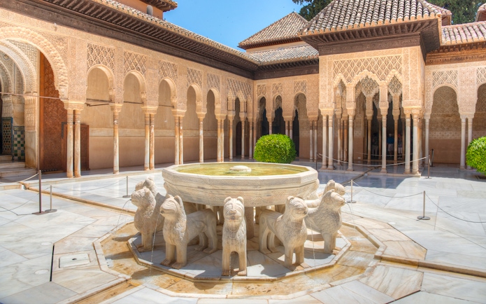 Courtyard of the Lions with ornate arches at Alhambra, Granada.