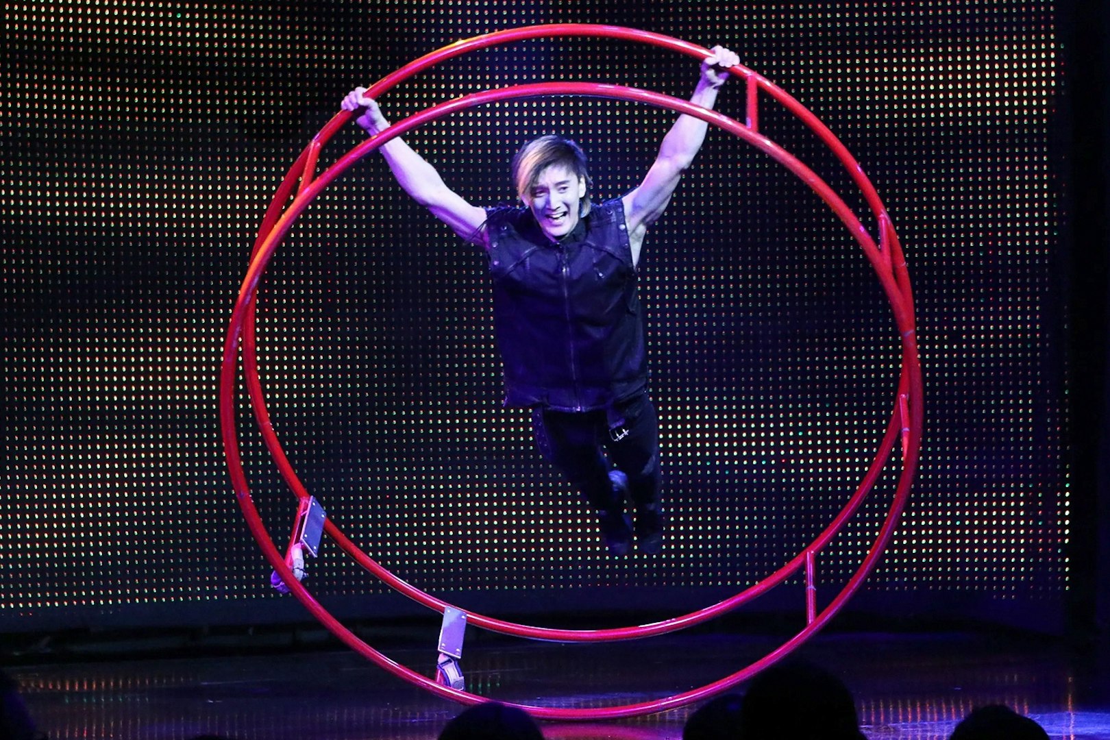 Performer in a red wheel at V - The Ultimate Variety Show.