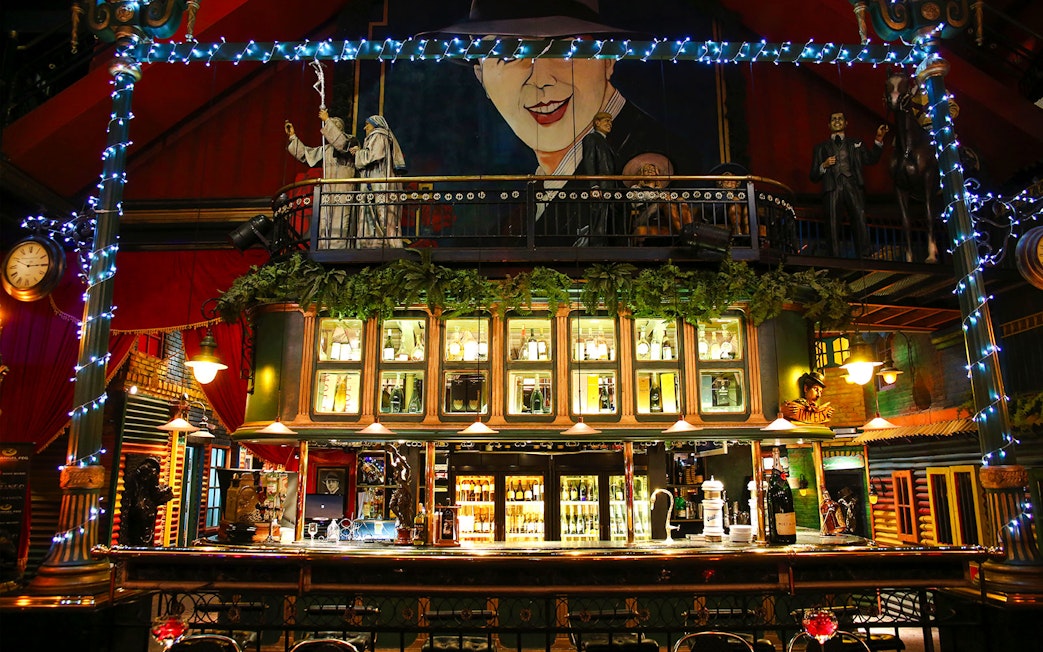 Bar area at Señor Tango Show with illuminated shelves and decorative elements.