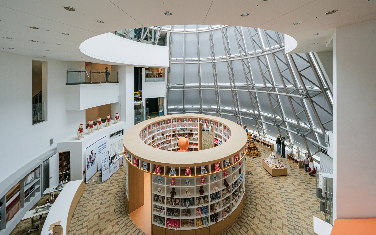 Teddy Bear Museum interior with circular display of teddy bears and visitors exploring exhibits.