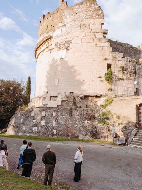 Tour group exploring ancient ruins on the Appian Way in Rome.