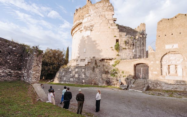 Tour group exploring ancient ruins on the Appian Way in Rome.