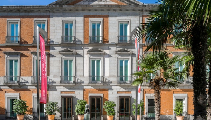 Visitors viewing art exhibits at Thyssen-Bornemisza Museum, Madrid, during a thematic tour with optional audioguide.