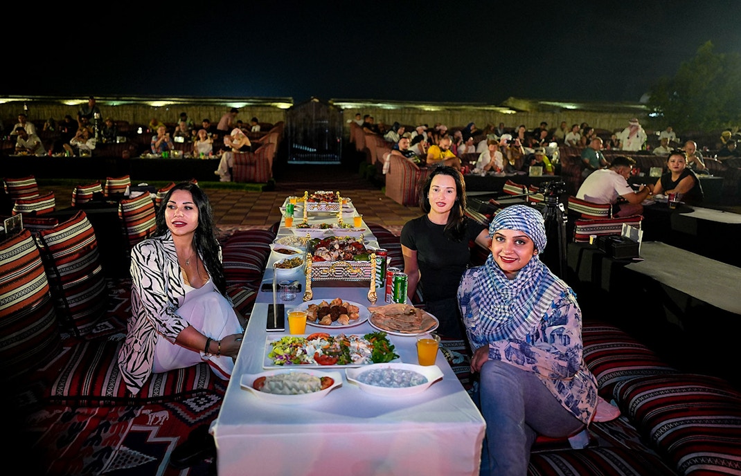 People enjoying live performance and dining at Dubai desert safari experience.