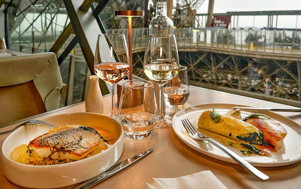 Dinner setting with fish and wine on the first floor of the Eiffel Tower, Paris.