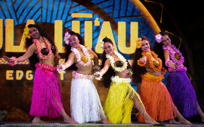 Hula dancers performing at Kaula-Luau in colorful skirts and floral leis.