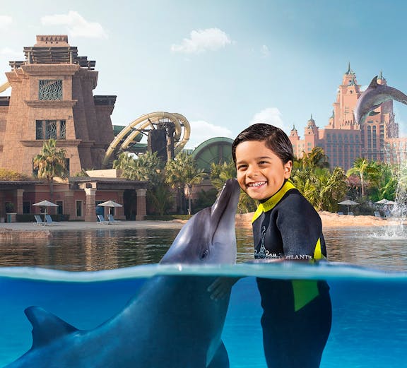 Child interacting with dolphin at Dolphin Bay, Aquaventure, Dubai.