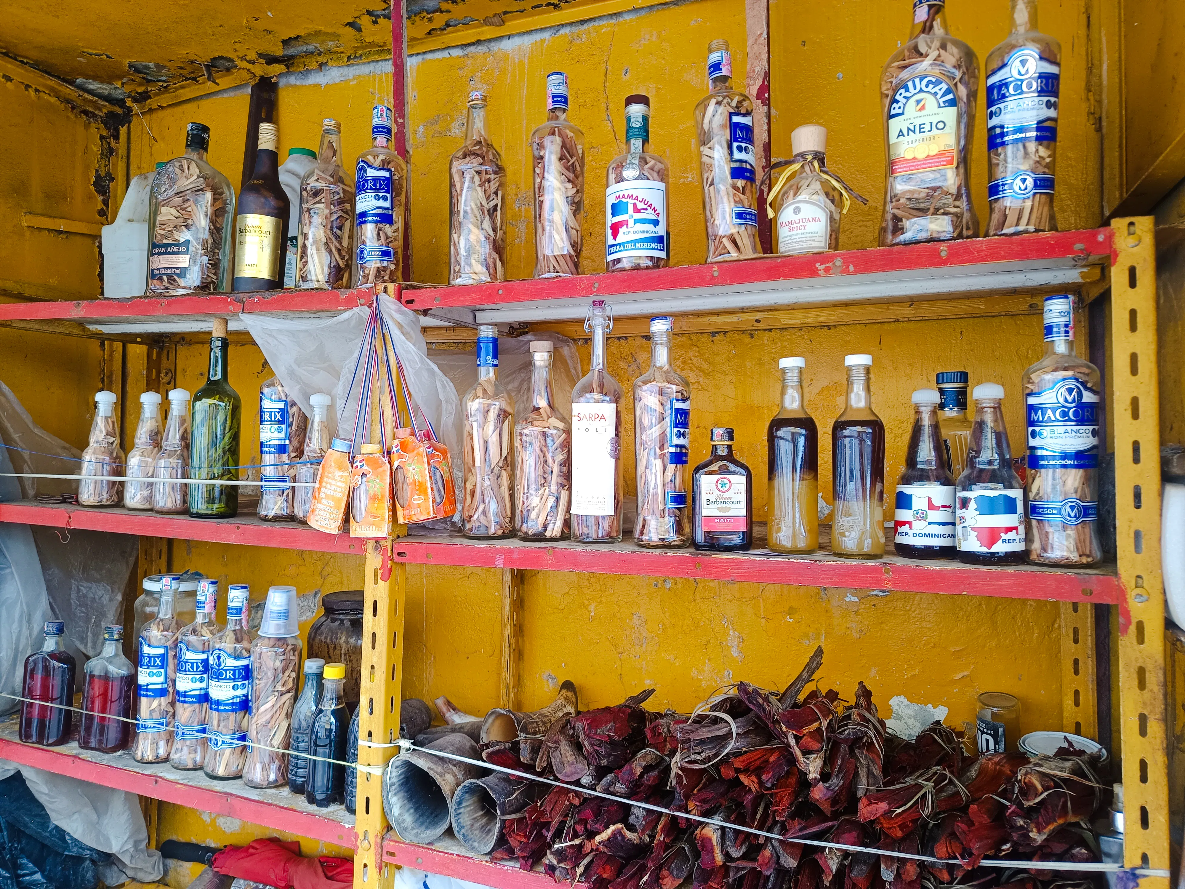 Bottles of Mamajuana on shelves at Mercado Modelo, Santo Domingo food tour.
