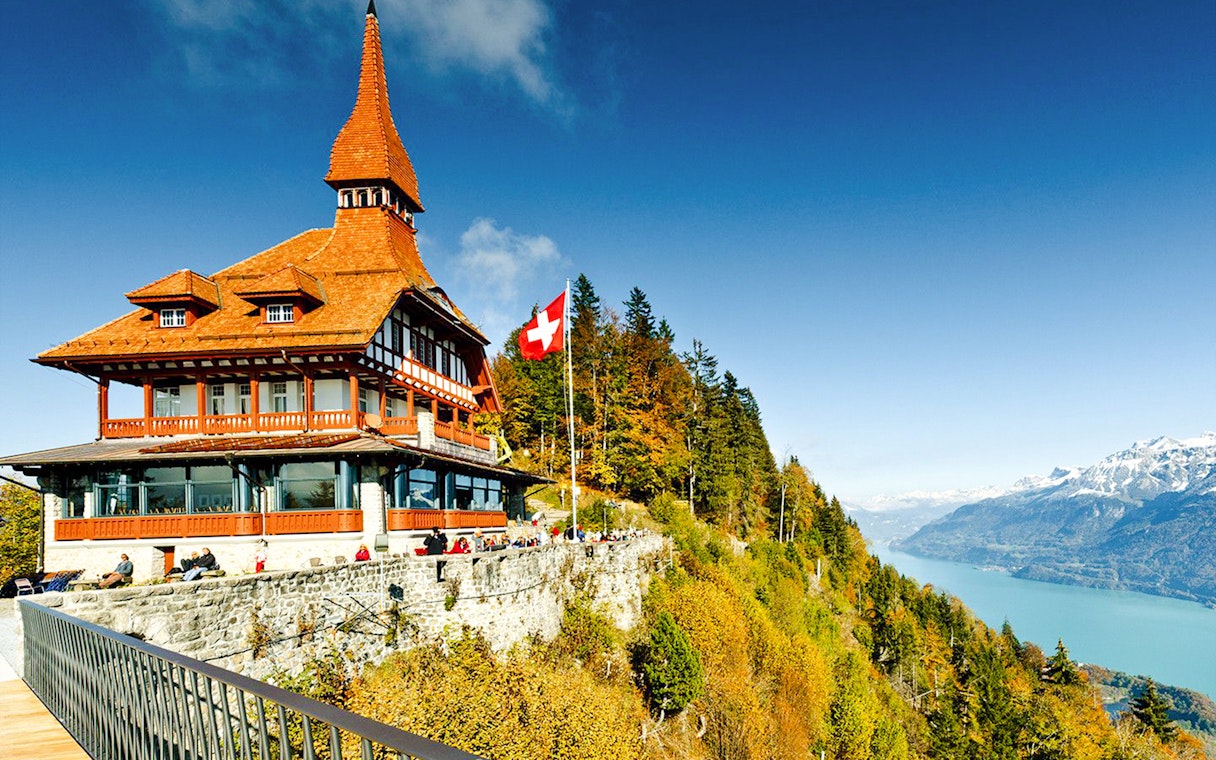 Harder Kulm viewpoint with Swiss flag, overlooking Lake Brienz and the Alps.
