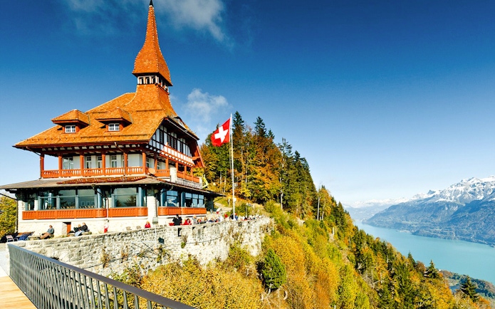Harder Kulm viewpoint with Swiss flag, overlooking Lake Brienz and the Alps.